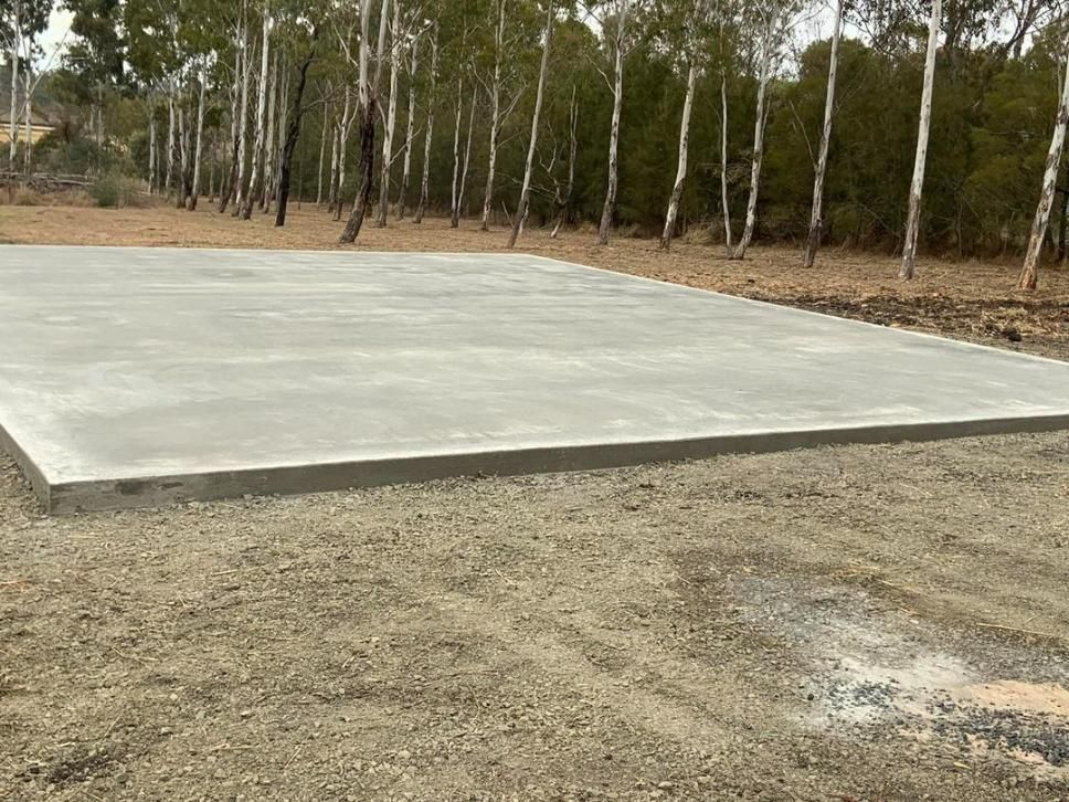 A Large Concrete Slab Is Sitting in The Middle of A Dirt Field — Pedro's Concreting in Pittsworth, QLD