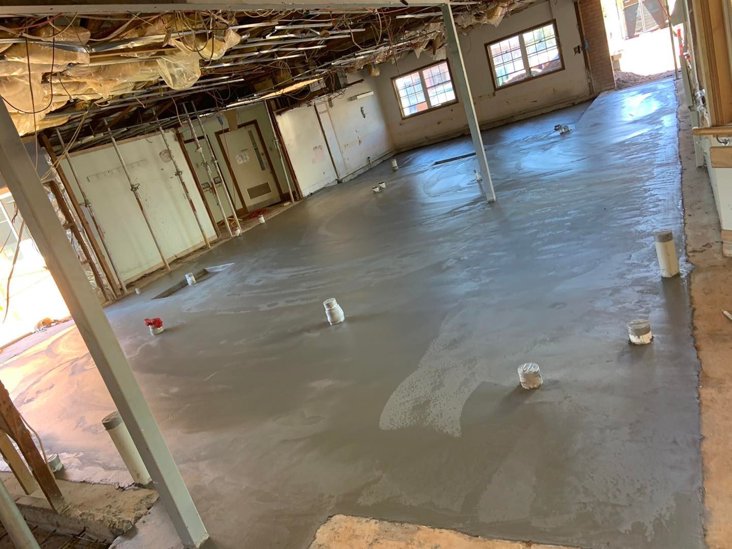 A Large Empty Room With a Concrete Floor and Pipes — Pedro's Concreting in Pittsworth, QLD