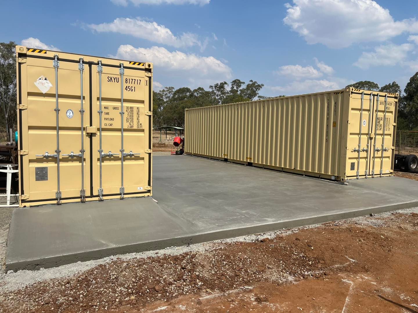 Two Shipping Containers Are Sitting Next to Each Other in a Parking Lot — Pedro's Concreting in Pittsworth, QLD