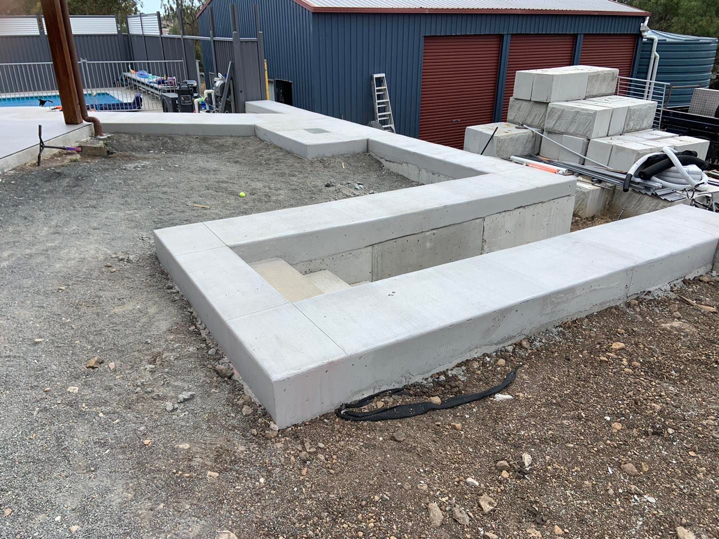 A Concrete Walkway is Being Built in Front of a Shed — Pedro's Concreting in Pittsworth, QLD