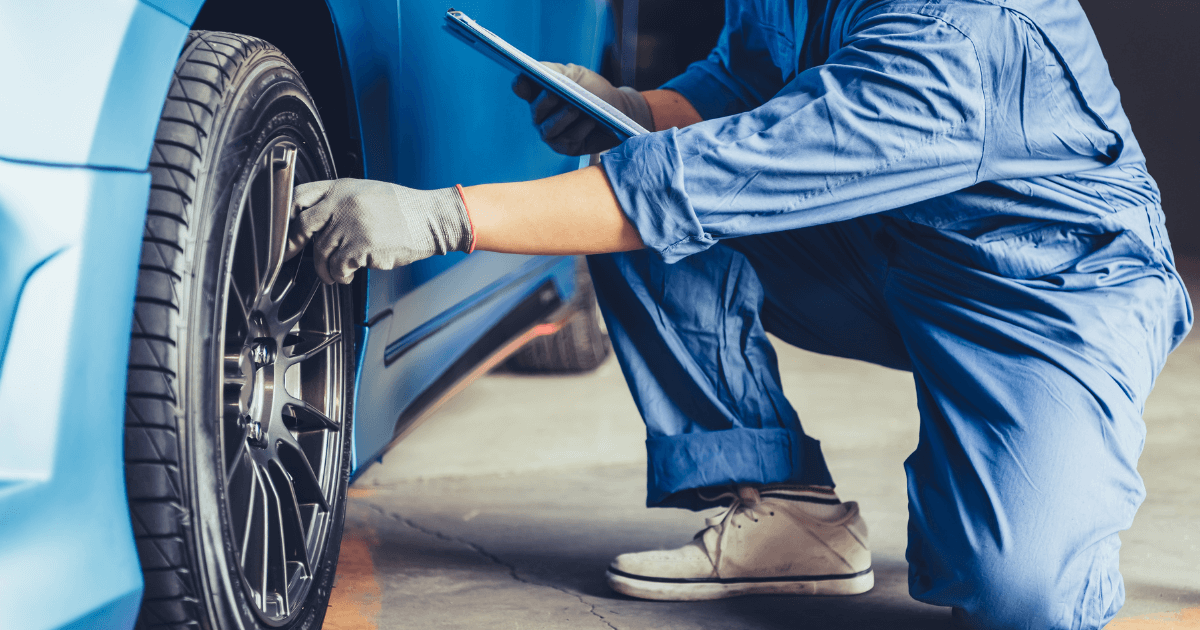 a mechanic doing a pre-purchase inspection on a white car