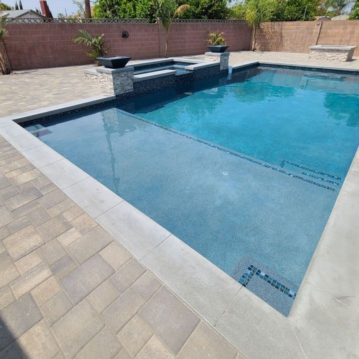 A large swimming pool surrounded by bricks and a brick wall