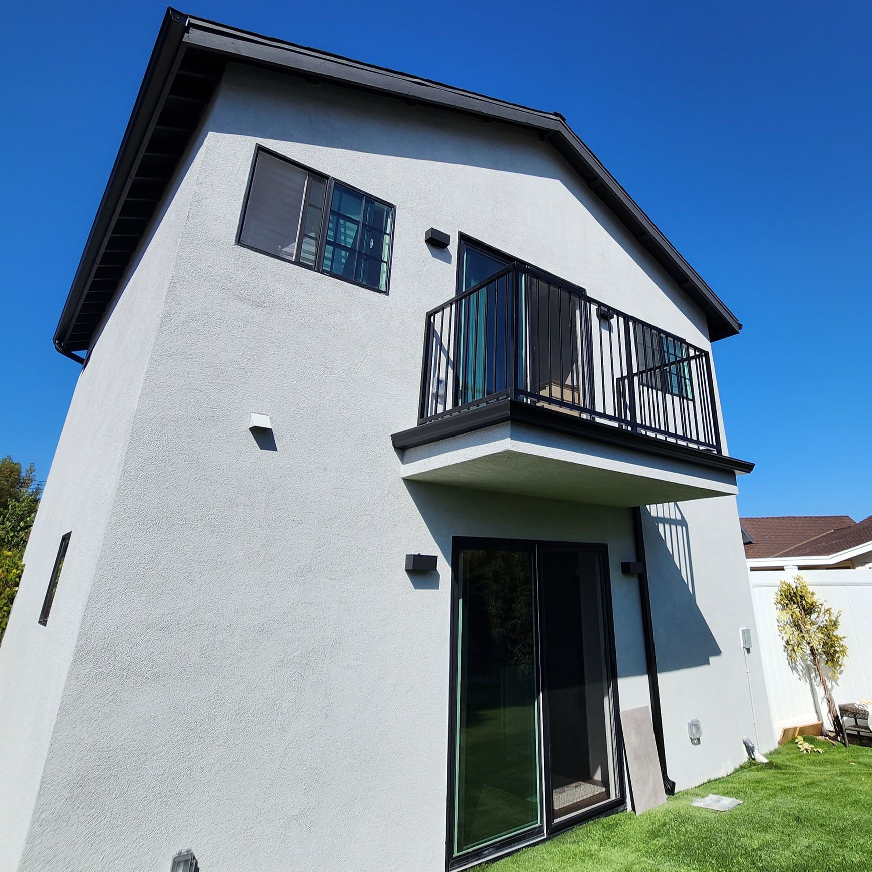 A white house with a balcony and sliding glass doors