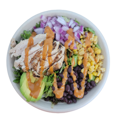 A bowl of salad with chicken , avocado , black beans , corn and onions.