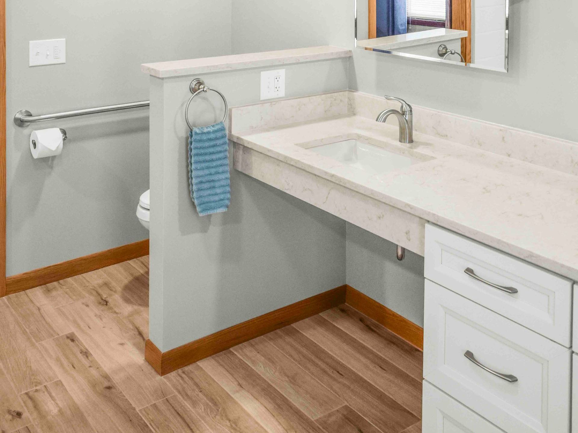 A bathroom with a sink, mirror, and drawers.