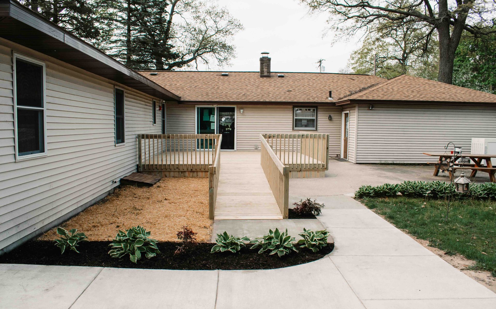 A house with a ramp and a picnic table in front of it