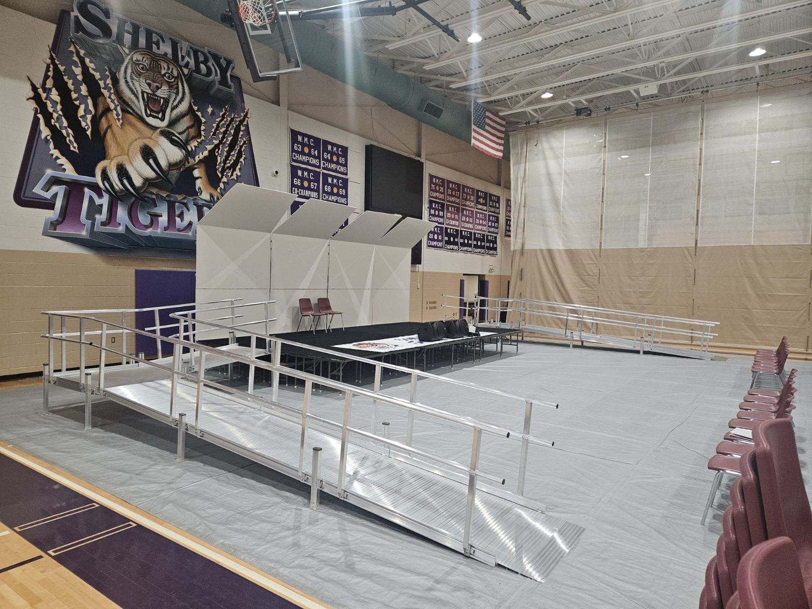 There is a ramp in the middle of the gym for school graduation.