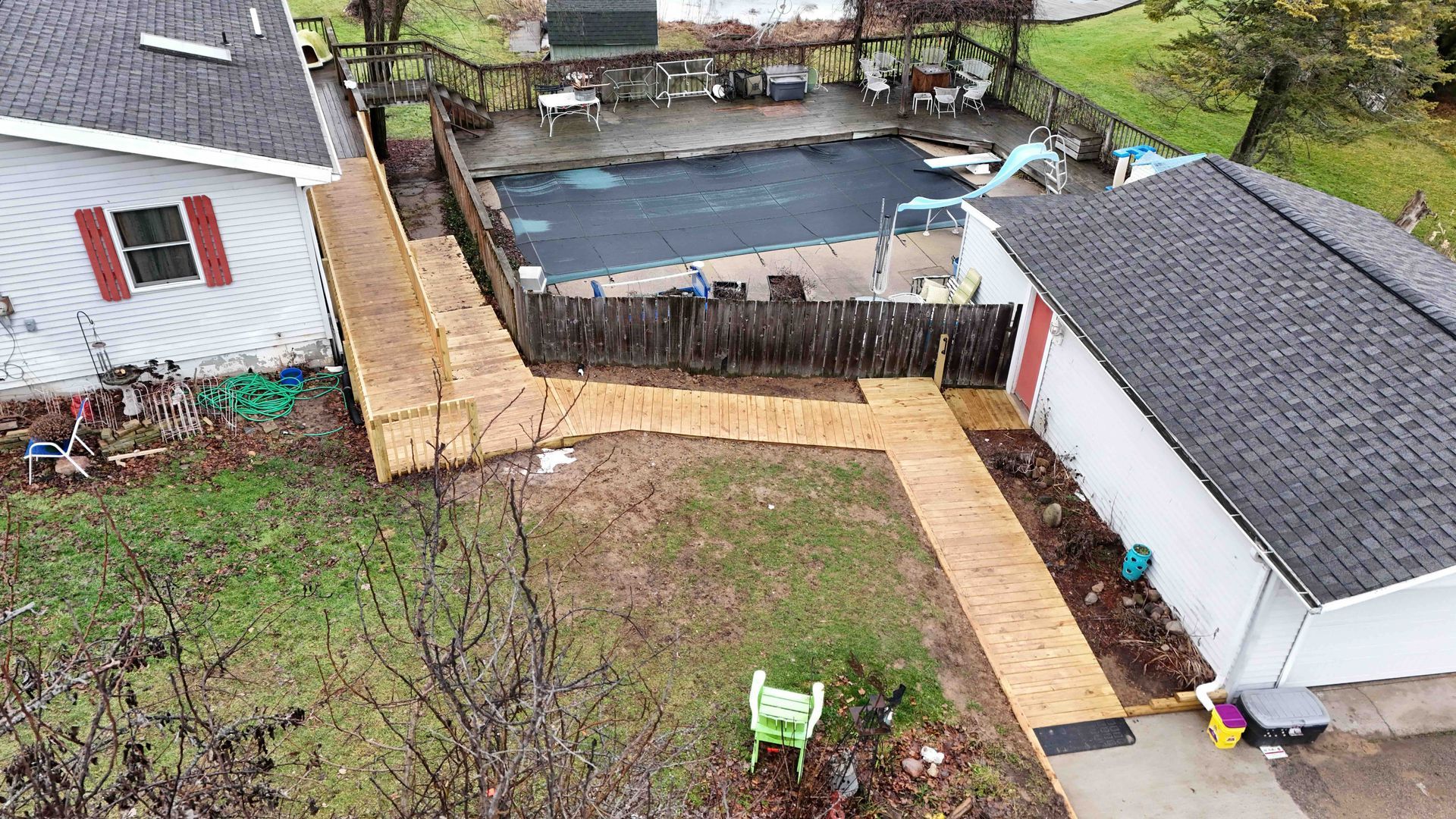An aerial view of a house with a swimming pool in the backyard and a wheelchair ramp.
