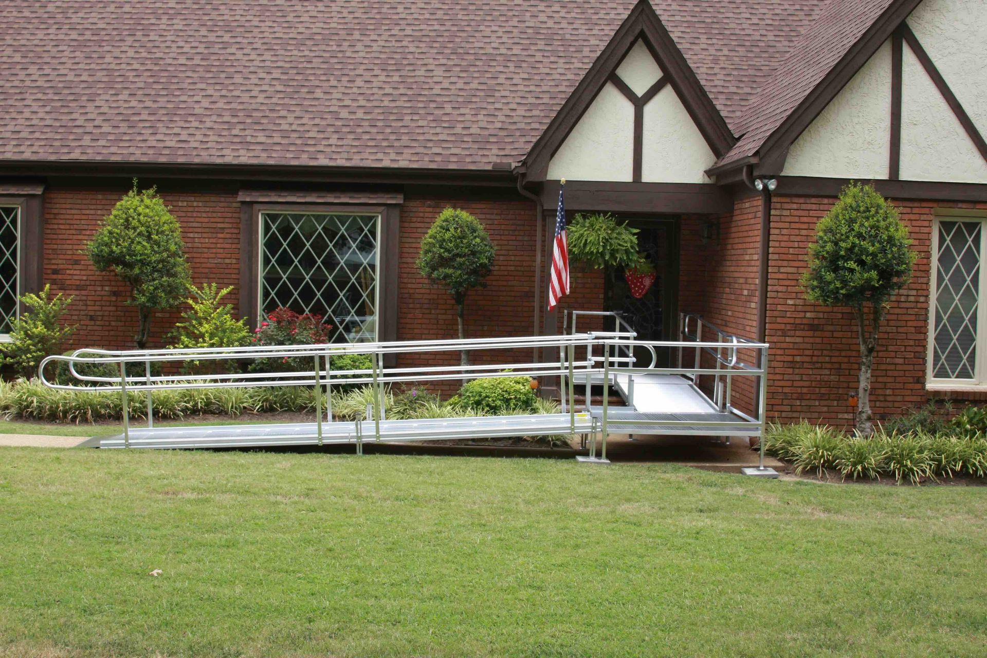 A brick house with a temporary wheelchair ramp in front of it.
