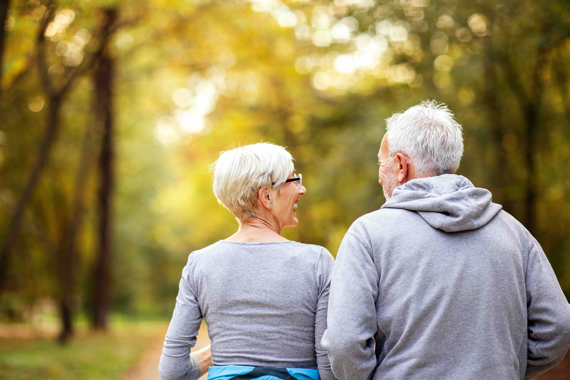 A man and a woman are walking in a park.