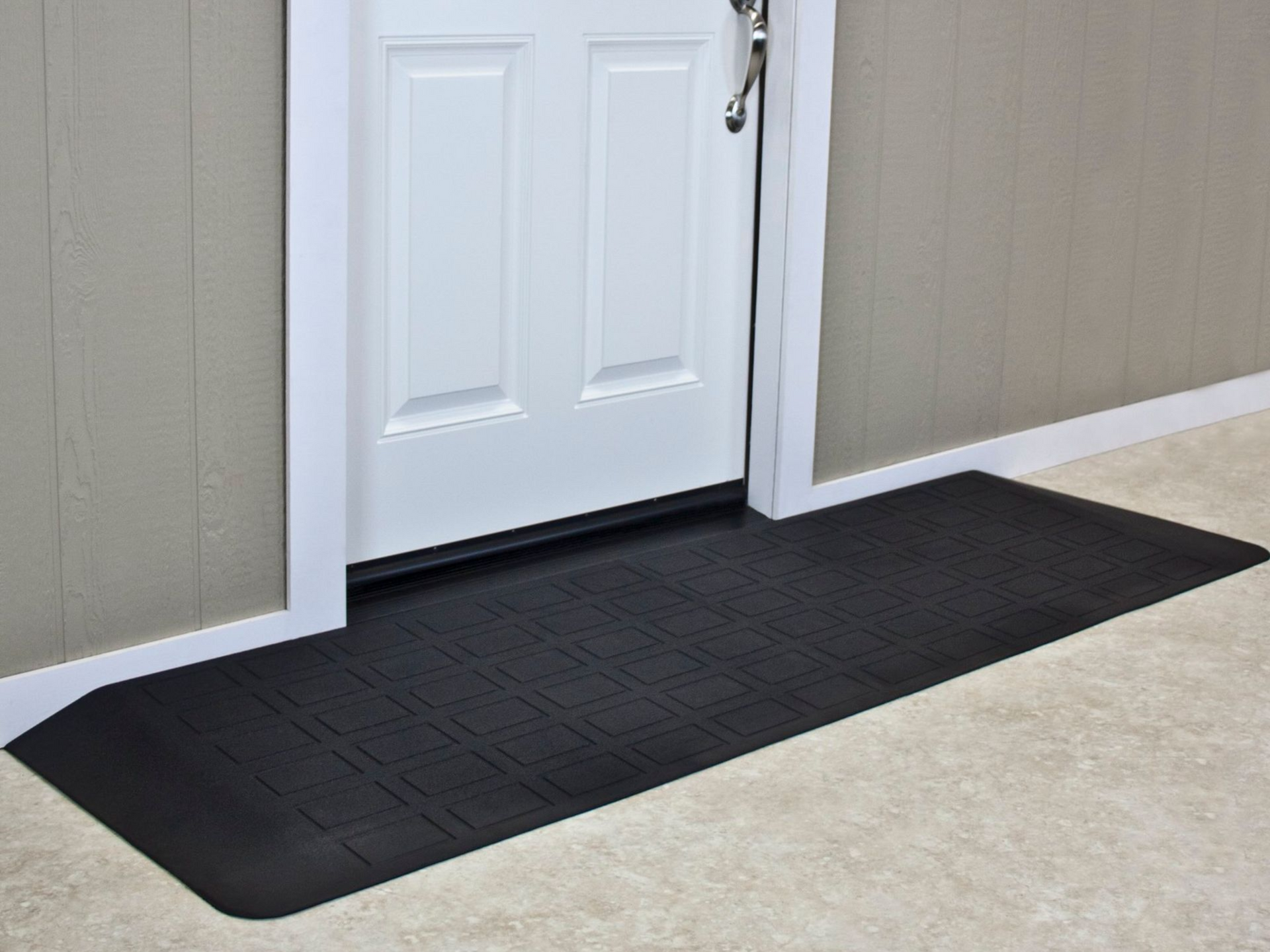 Black rubber ramp at a doorway, providing wheelchair access.