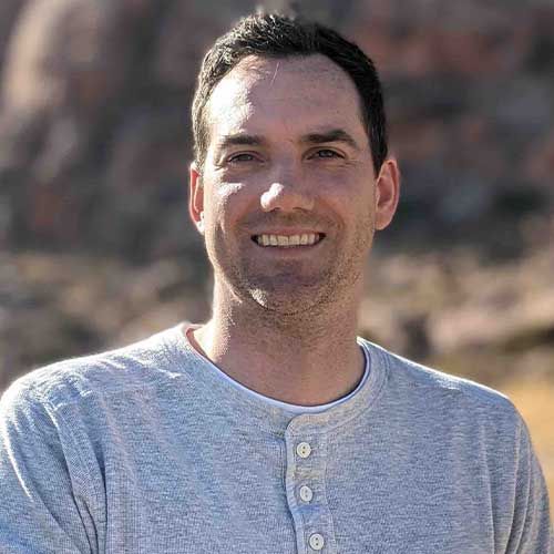 Steven Speckman, the owner of Speck Designs in front of mountains.