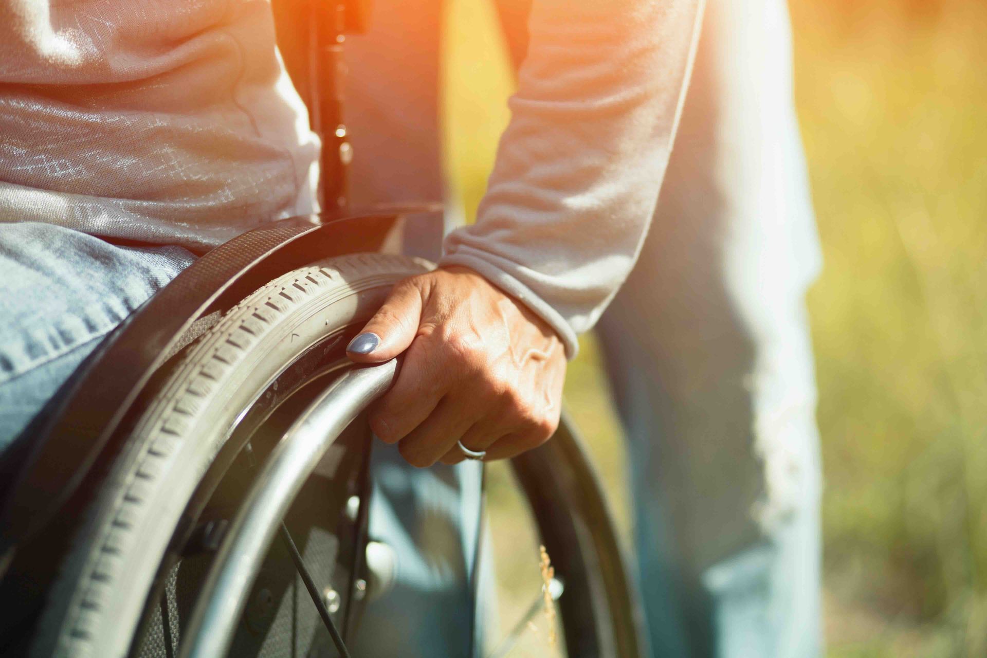 A woman in a wheelchair is holding the wheel.