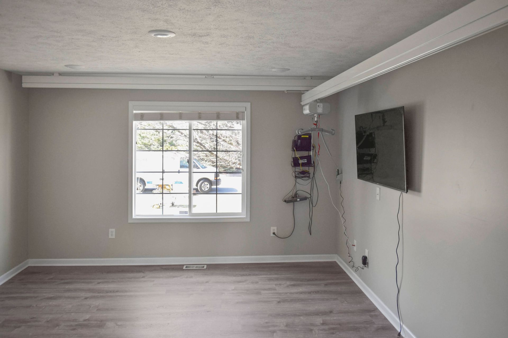 An empty bedroom with a ceiling lift installed for maneuverability.