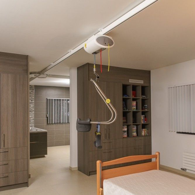 a bedroom with a bed and a lift hanging from the ceiling.