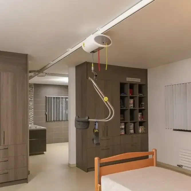 a bedroom with a bed and a lift hanging from the ceiling.
