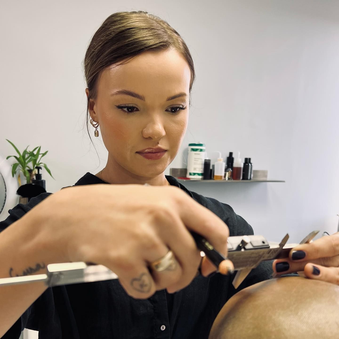 A woman is cutting a man 's hair in a salon