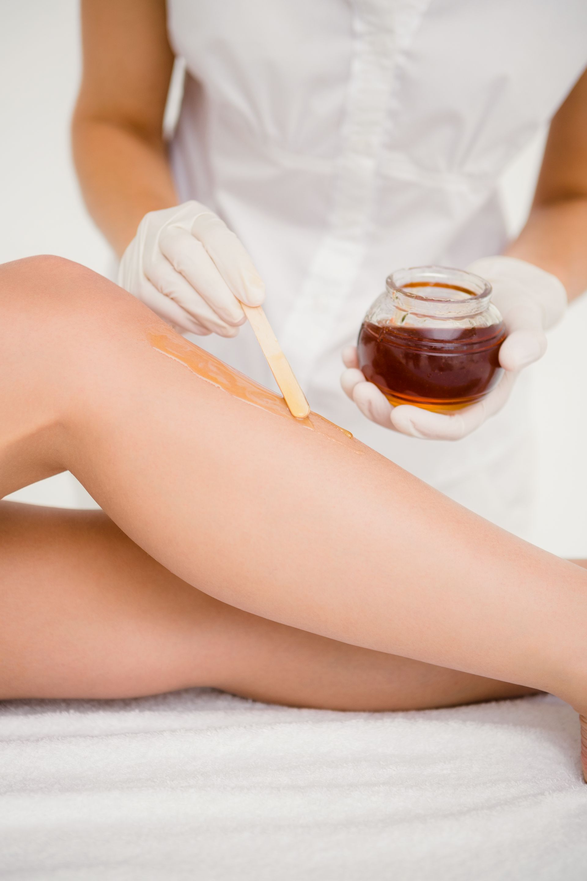 A woman is getting her legs waxed in a beauty salon.