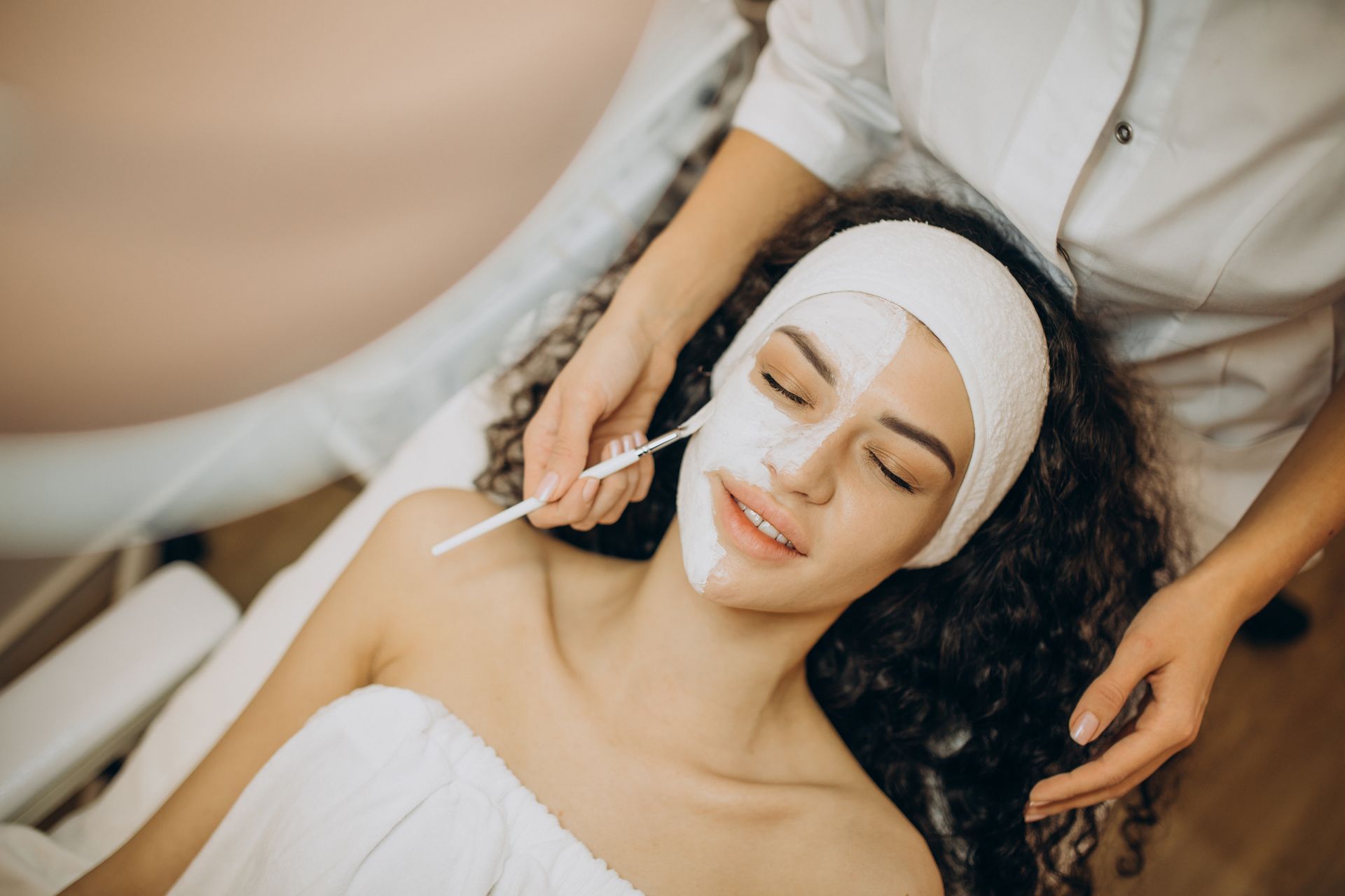 A woman is getting a facial treatment at a spa.