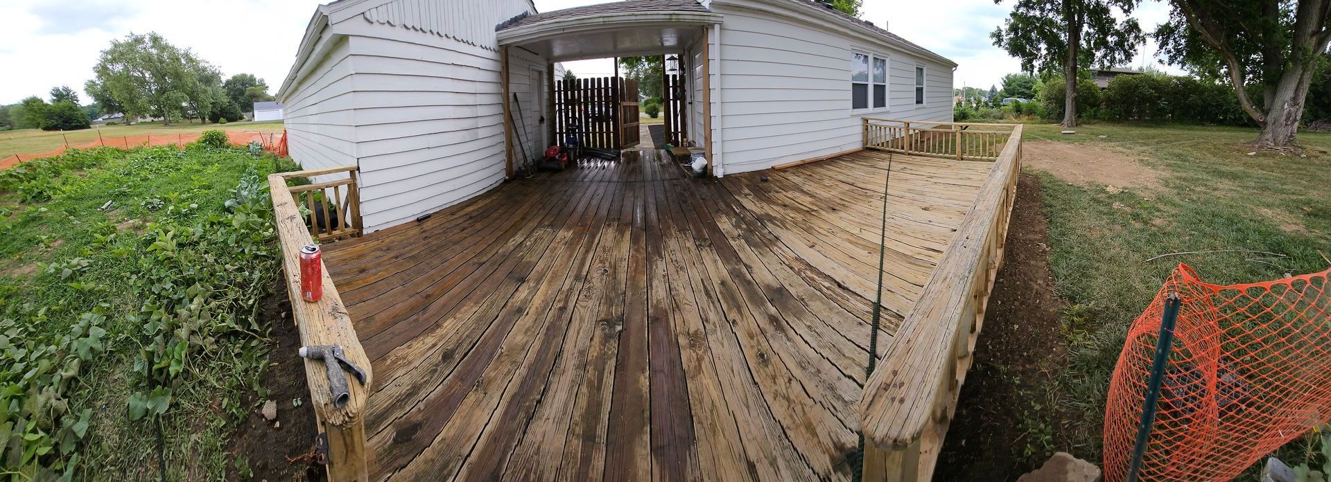 A white house with a wooden deck in front of it.