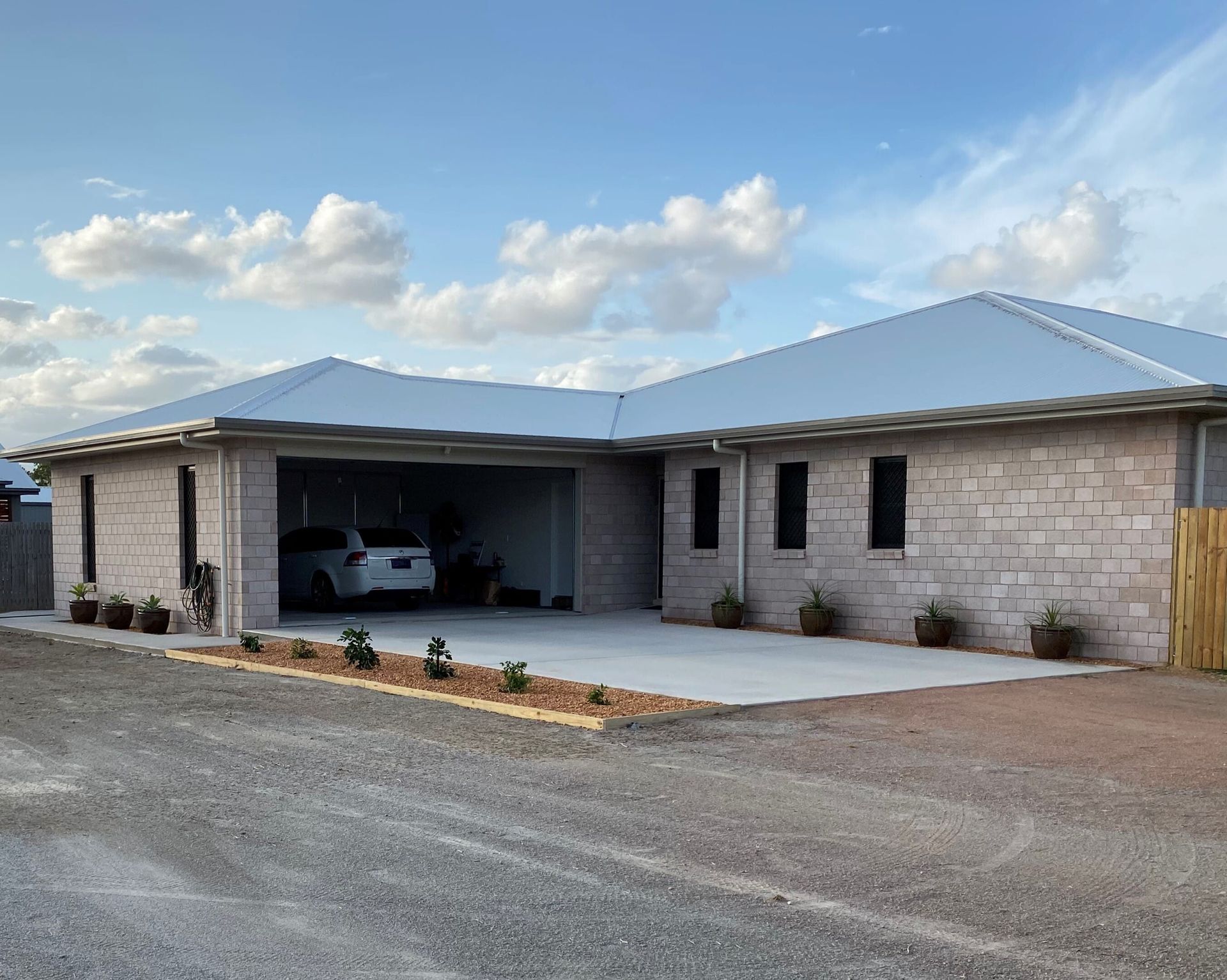 A Modern House With A Lot Of Windows And A Large Driveway — Darryl Tickle Building Pty Ltd In Alice River, QLD