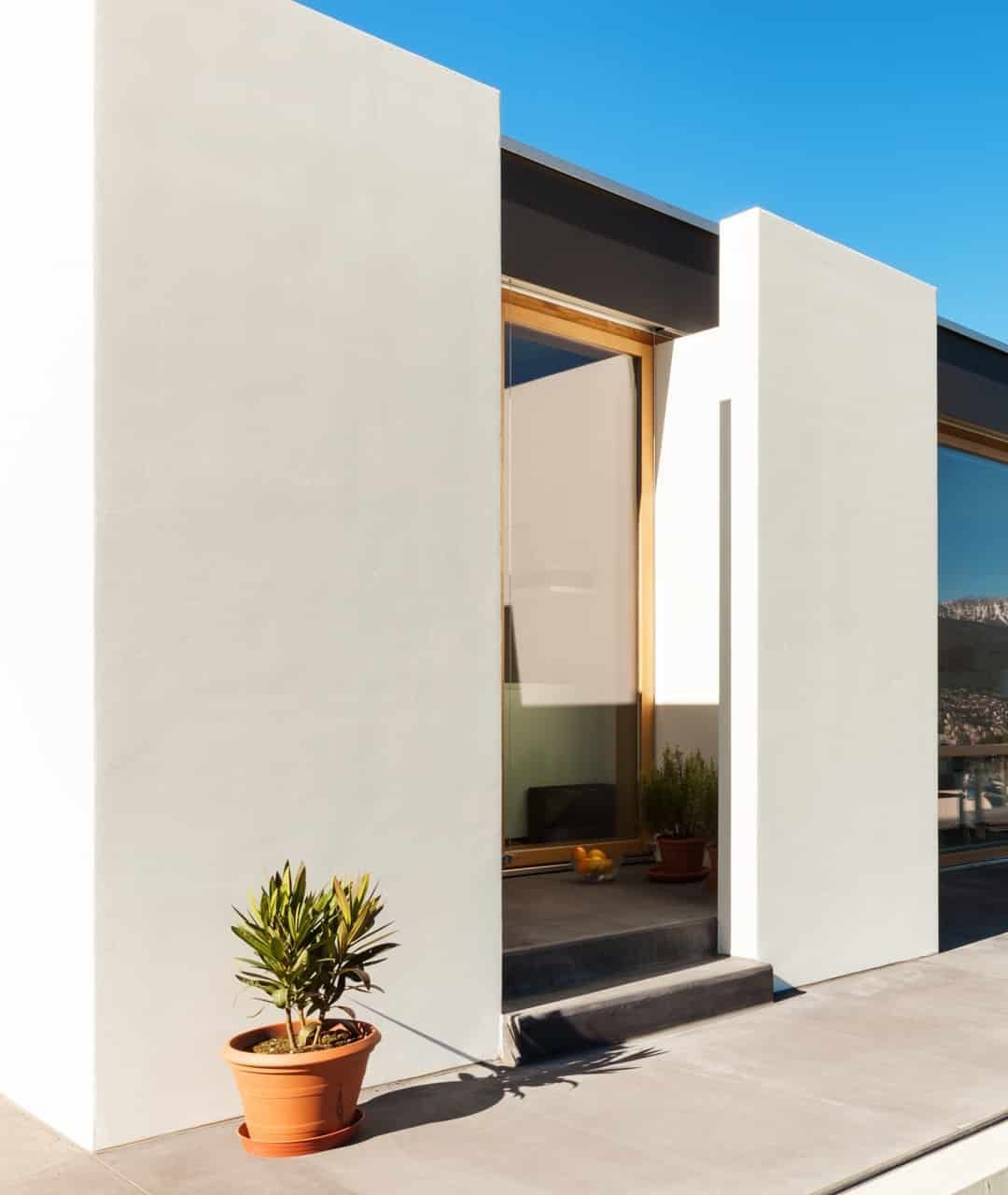 A White Building With A Potted Plant In Front Of It — Darryl Tickle Building Pty Ltd In Alice River, QLD
