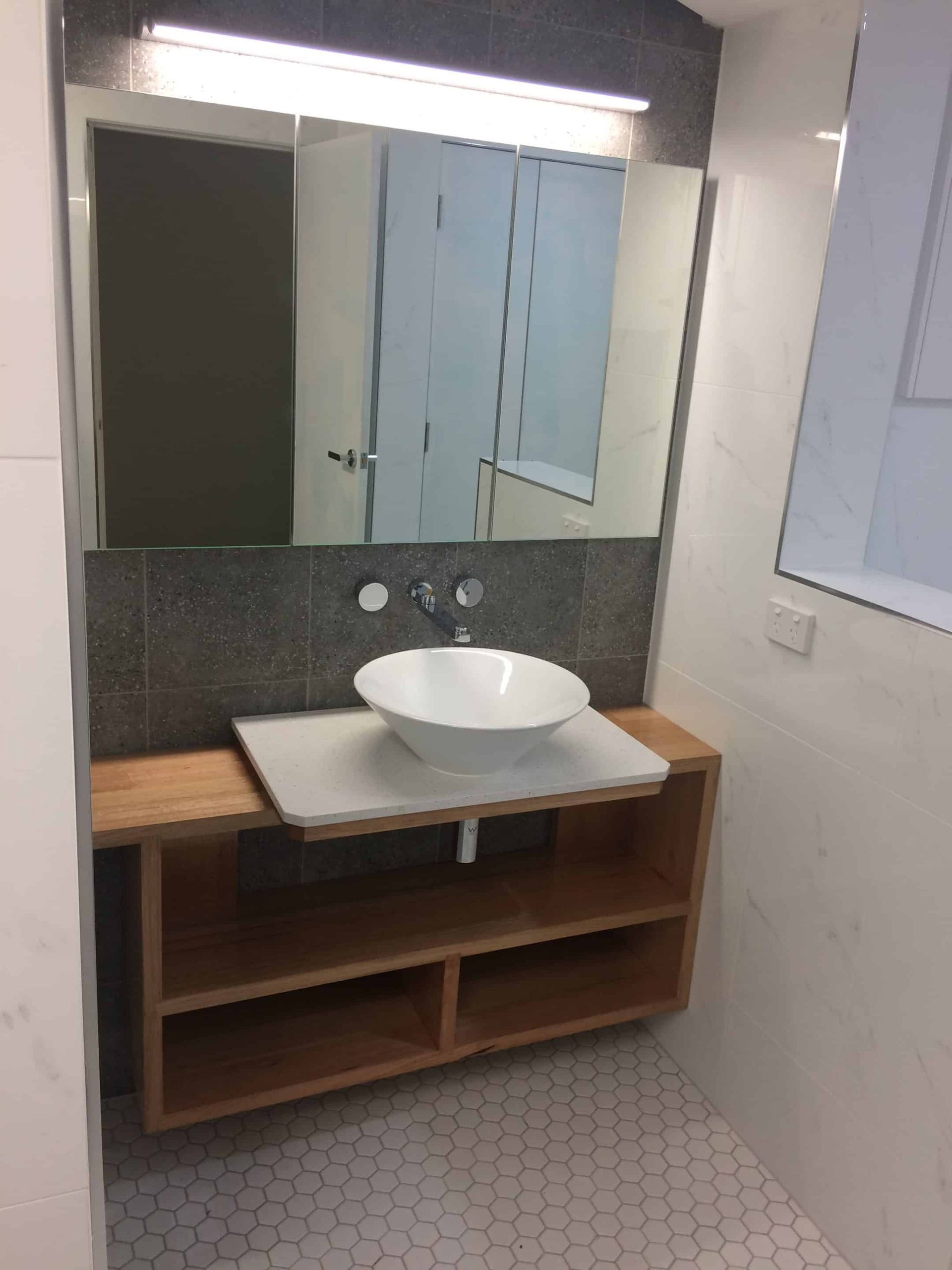 A Bathroom With A Sink And A Large Mirror — Darryl Tickle Building Pty Ltd In Alice River, QLD