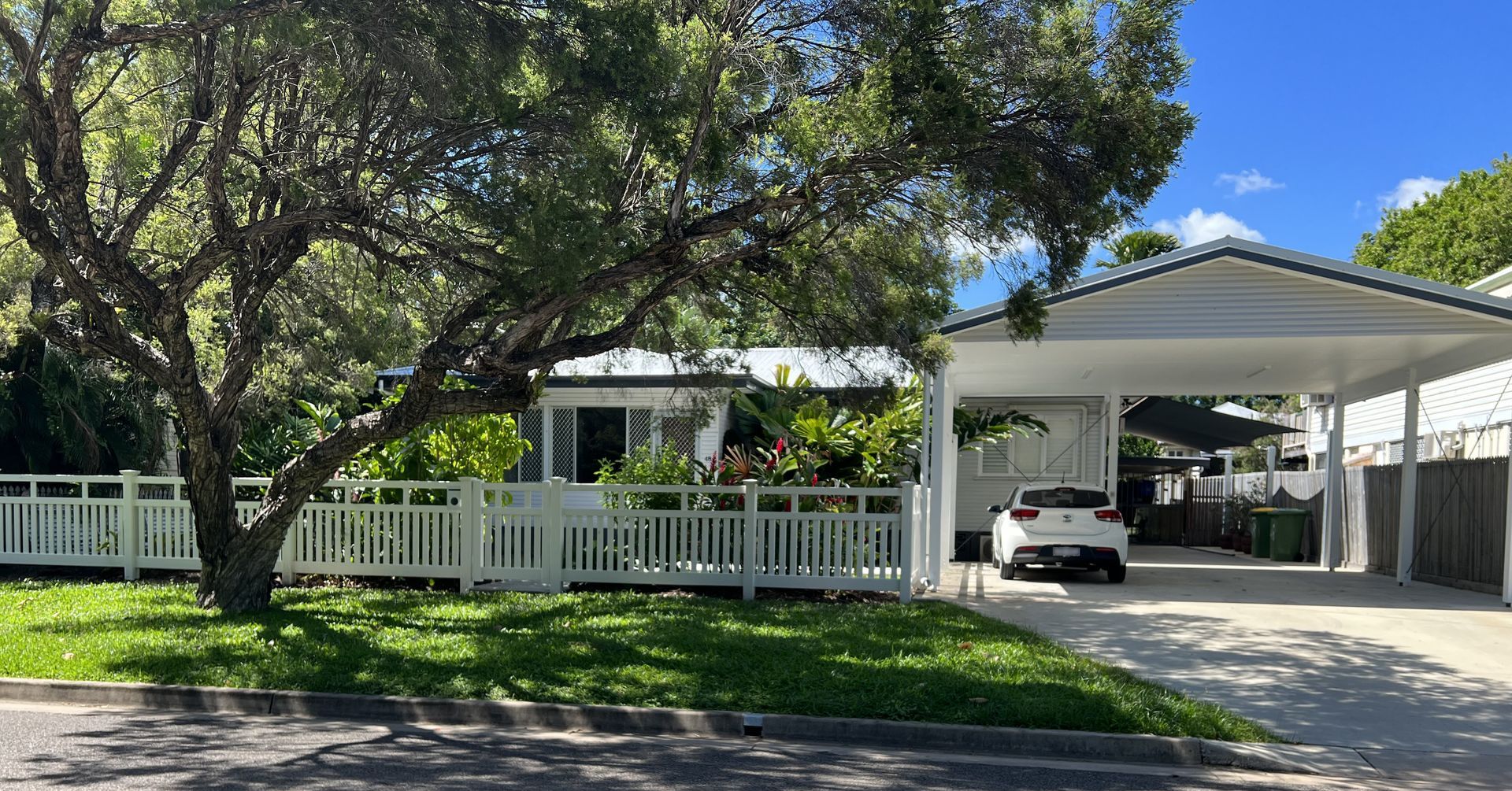 A White Car Is Parked Under A Carport In Front Of A House — Darryl Tickle Building Pty Ltd In Alice River, QLD