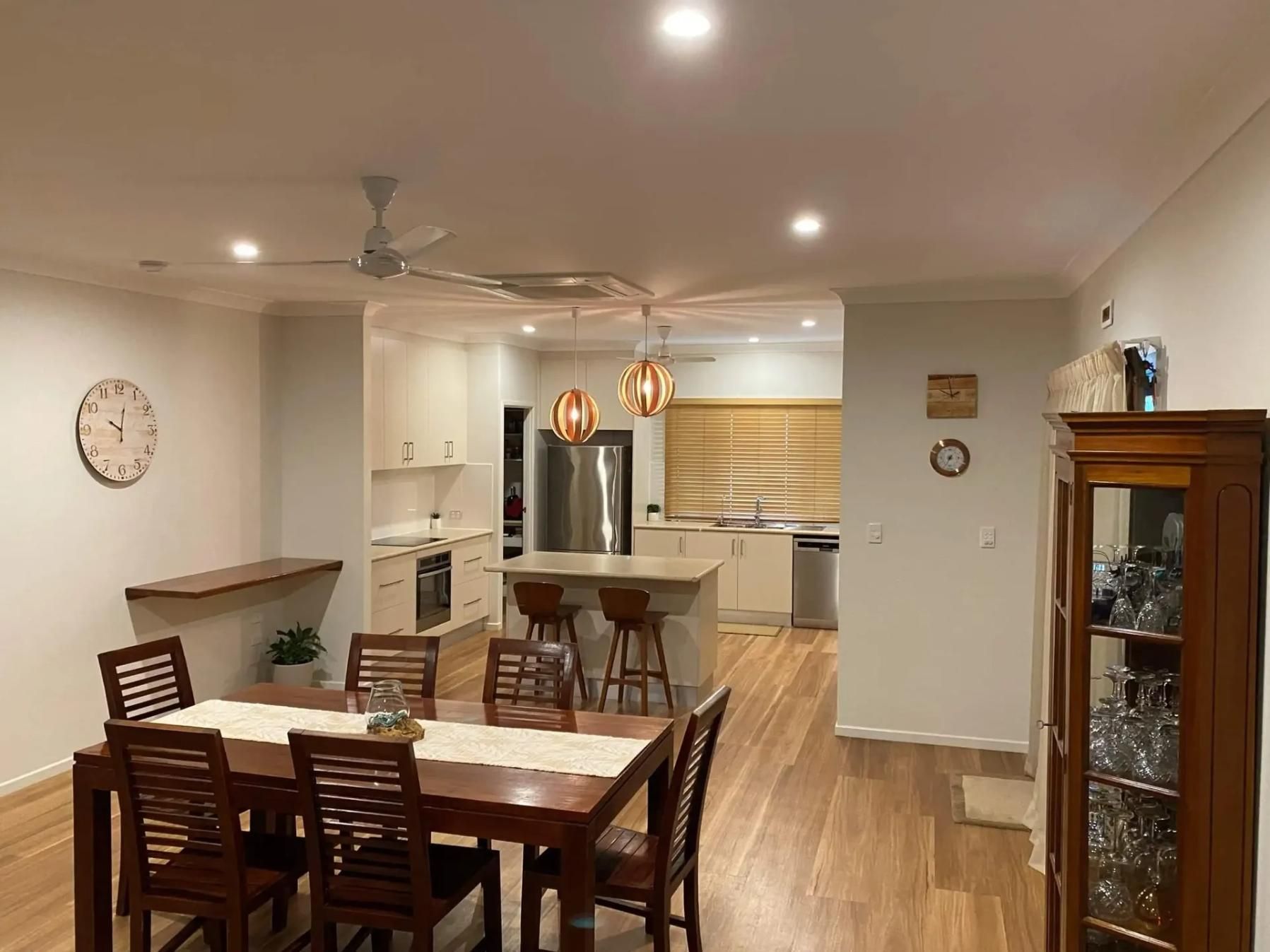 A Dining Room With A Table And Chairs And A Clock On The Wall — Darryl Tickle Building Pty Ltd In Alice River, QLD