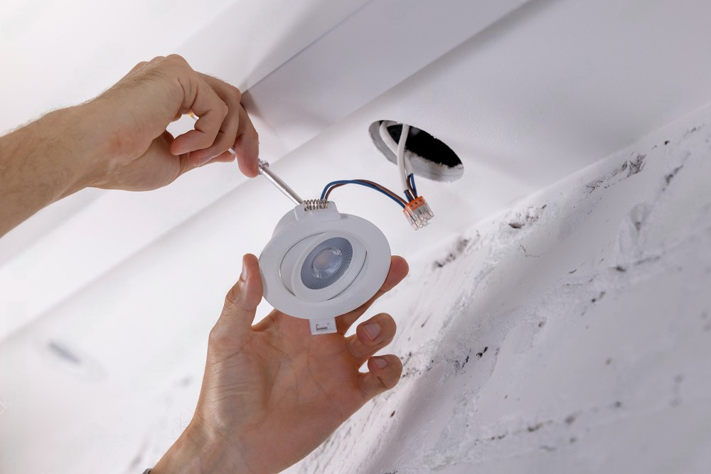 a person is installing a light with a screwdriver