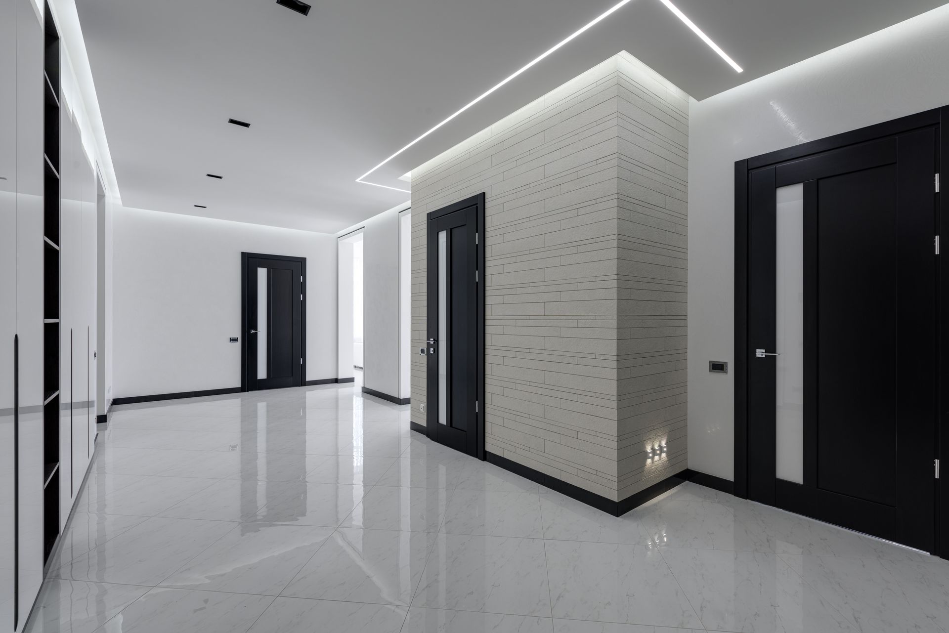 Modern and stylish white hallway in a spacious apartment, illuminated with elegant LED lights on the ceiling.