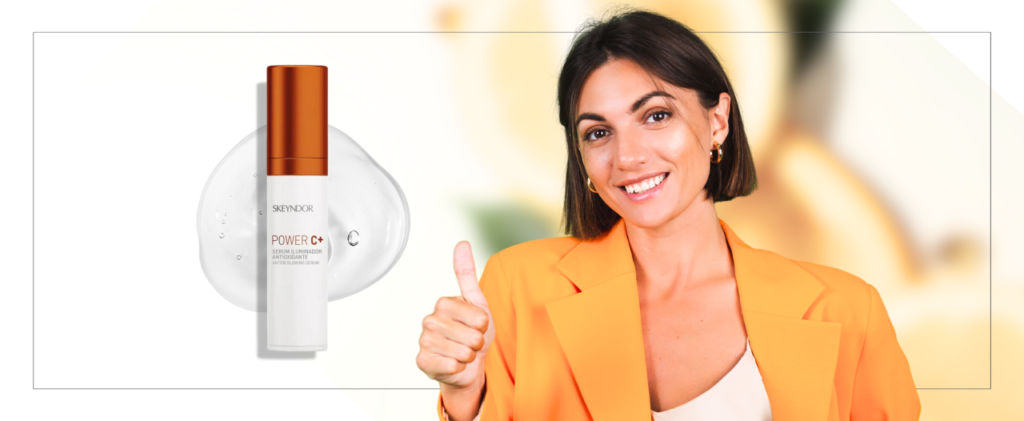 Una mujer con una chaqueta naranja levanta el pulgar junto a un Serum Power C+