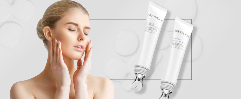 una mujer se toca la cara frente a dos tubos de Contorno de Ojos Power Hyaluronic