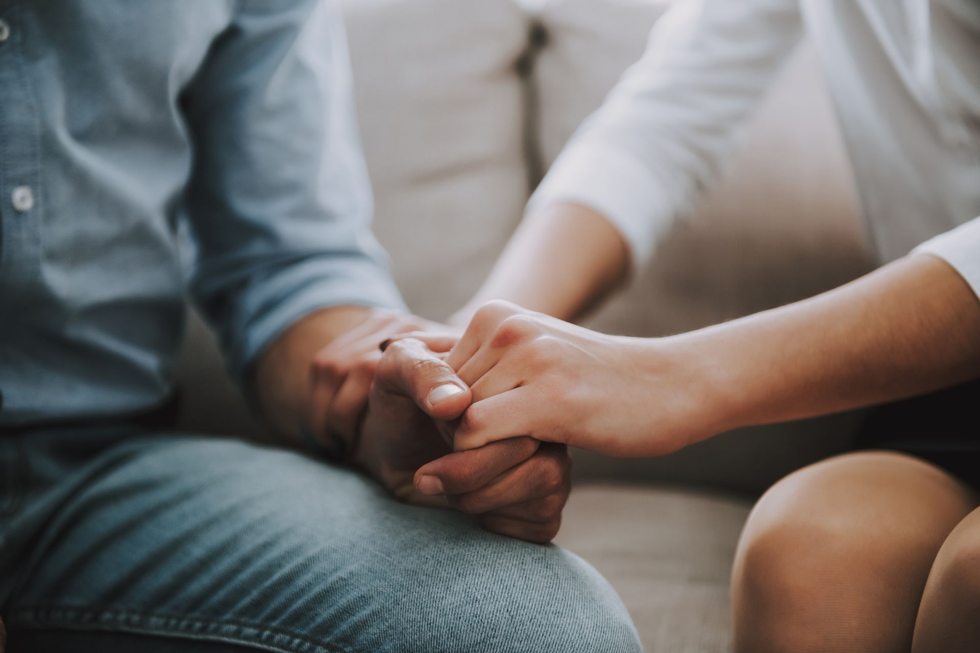 Young couple holding hands in counselling session