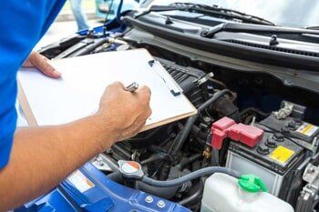 Mechanic man holding clipboard and check the car — Auto Repair in Denton, Texas