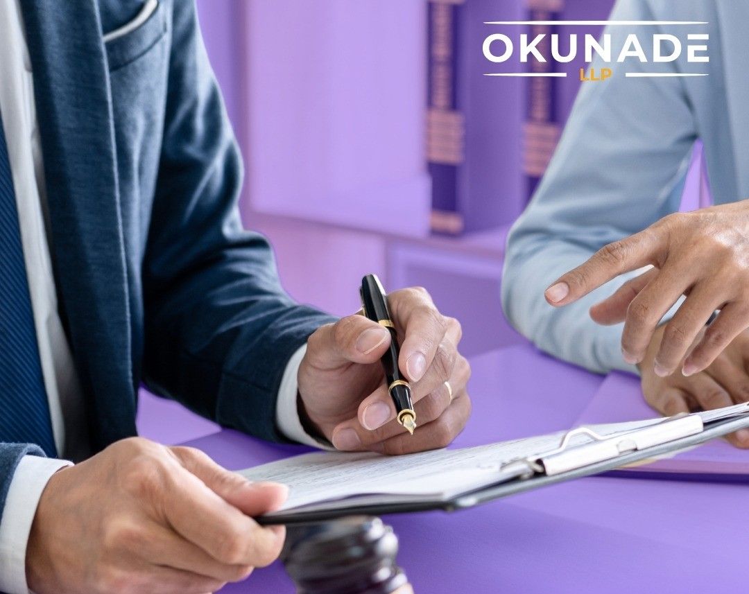 Business owner reviewing employee handbook and compliance documents at a desk with documents