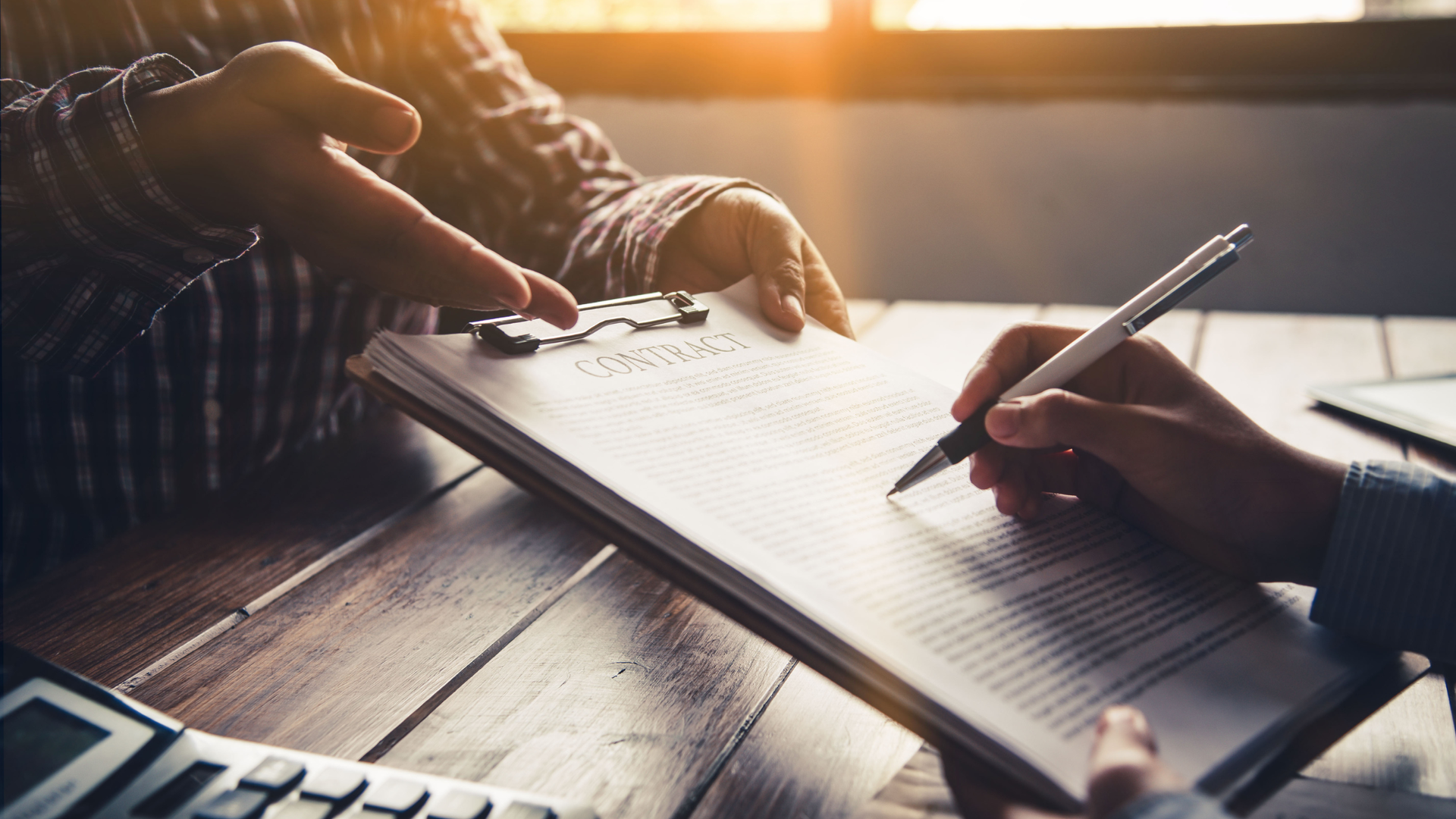 Business owner reviewing and signing a contract agreement with advisor