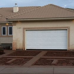 A house with a white garage door and a brown roof.