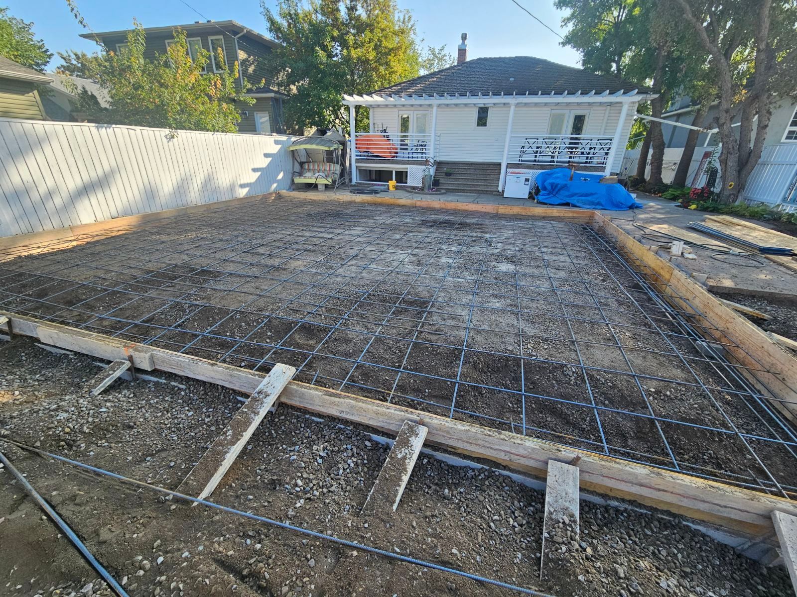 A concrete slab is being built in front of a house.