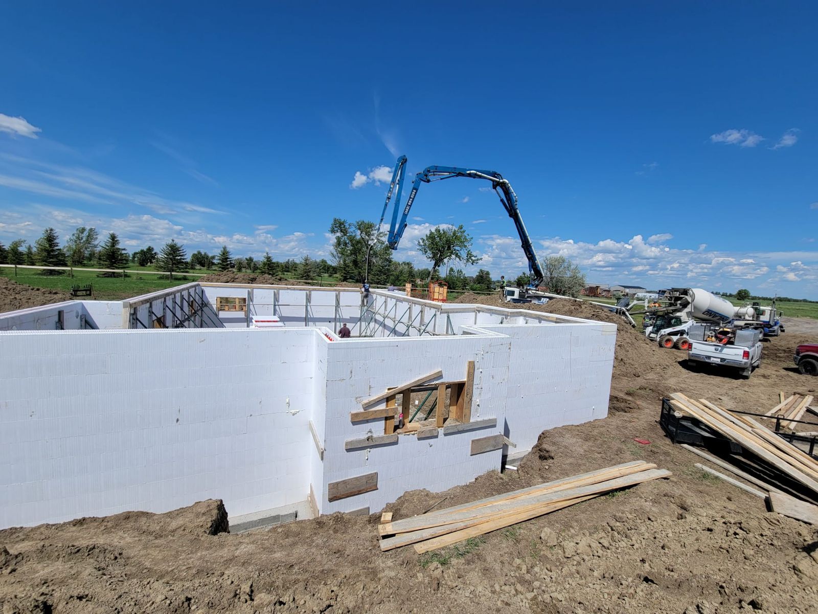 A concrete pump is being used to pour concrete into a building under construction.