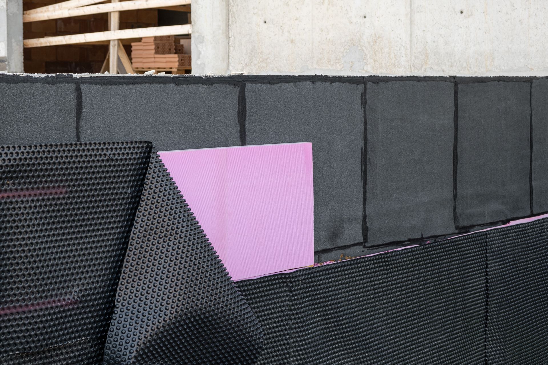 A purple piece of styrofoam is laying on a wall