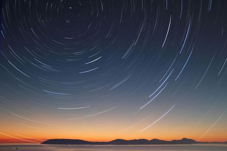 A starry night sky over a body of water