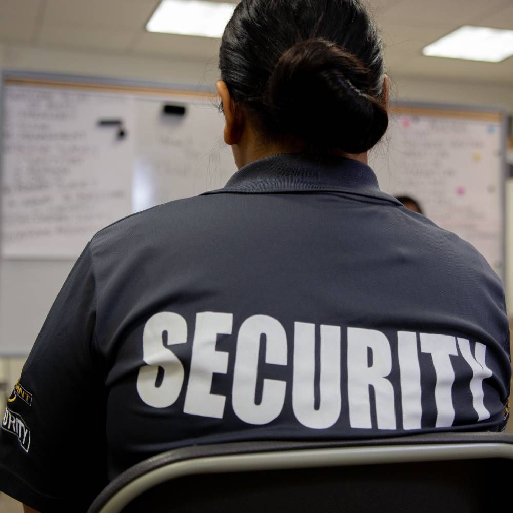 A woman is wearing a black shirt that says security on the back