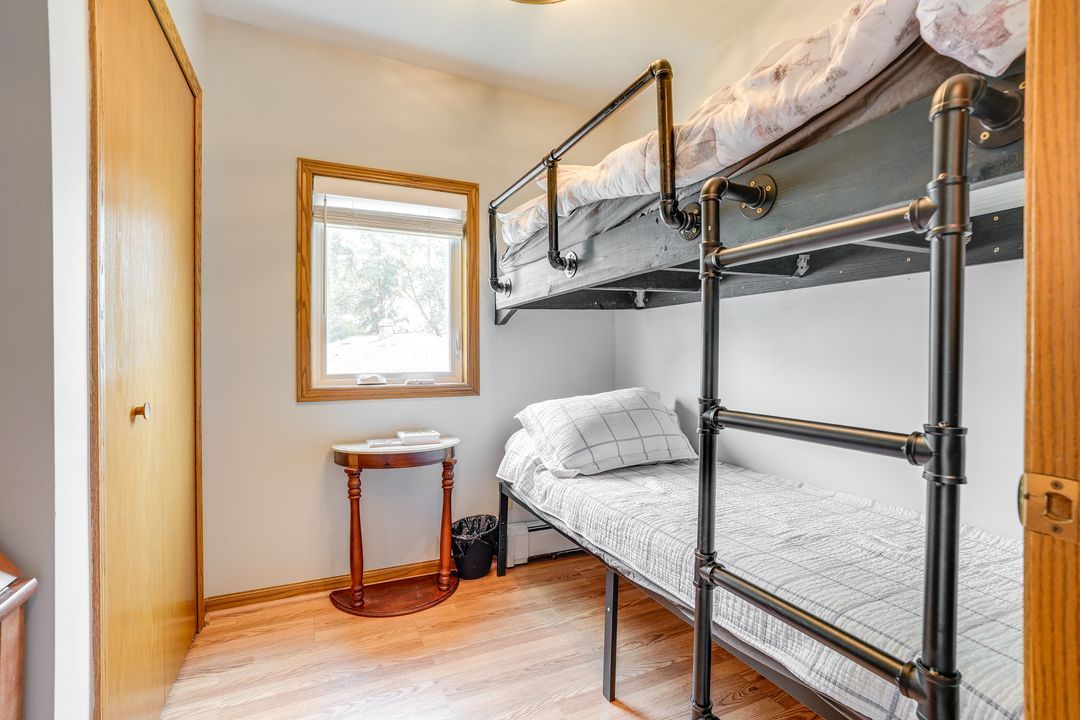 Small bedroom with bunk beds, window, and a small table.