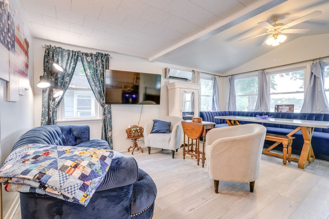 Cozy living room with blue furniture, built-in booth seating, and a TV mounted on the wall.
