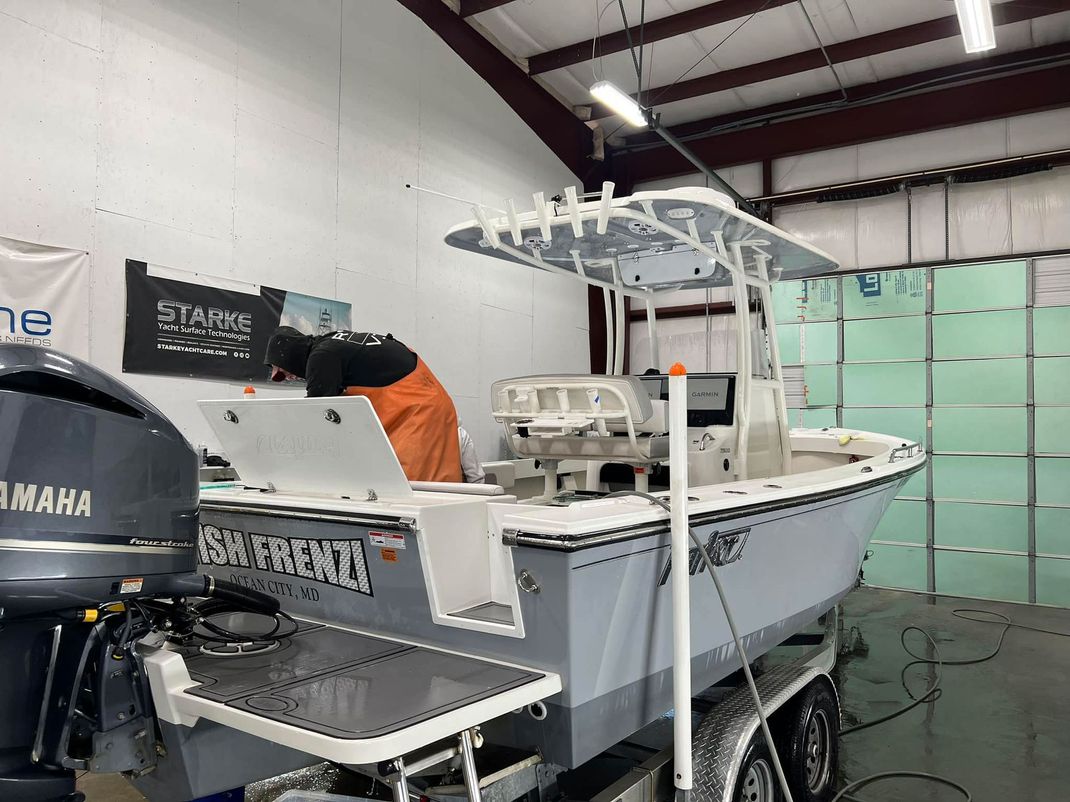 A boat with a yamaha engine is sitting in a garage.