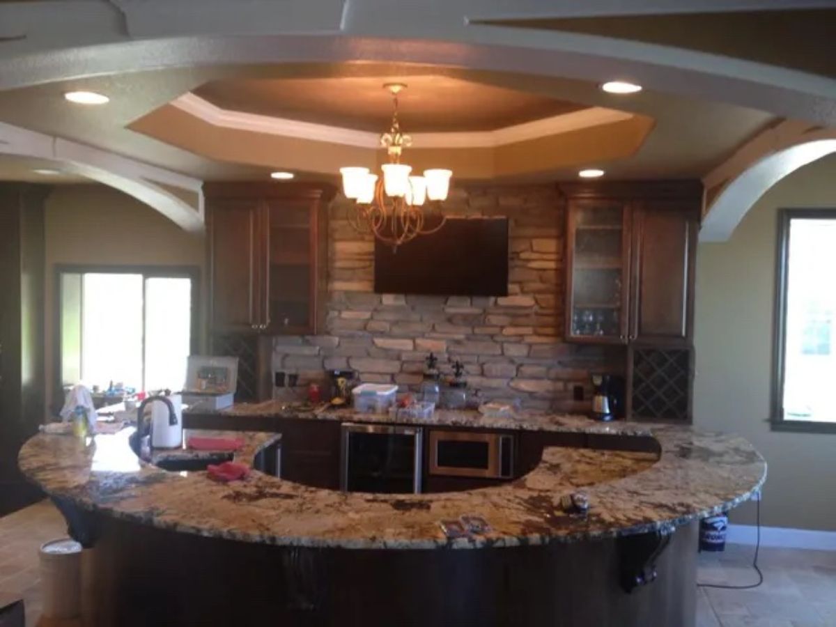 a kitchen with granite counter tops and a brick wall