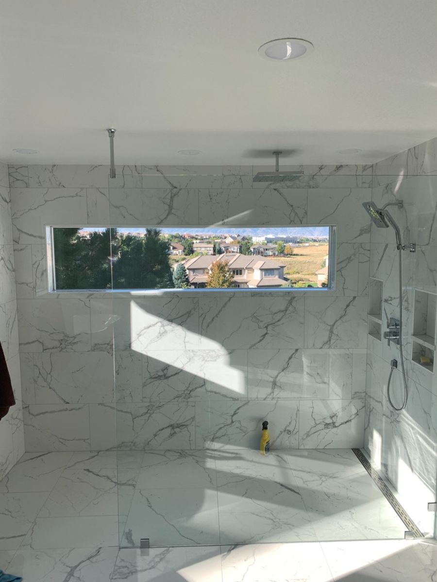 a bathroom with a walk in shower and a window .