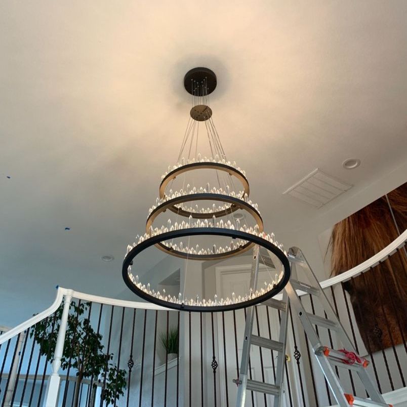 a large chandelier is hanging from the ceiling in a room with a ladder