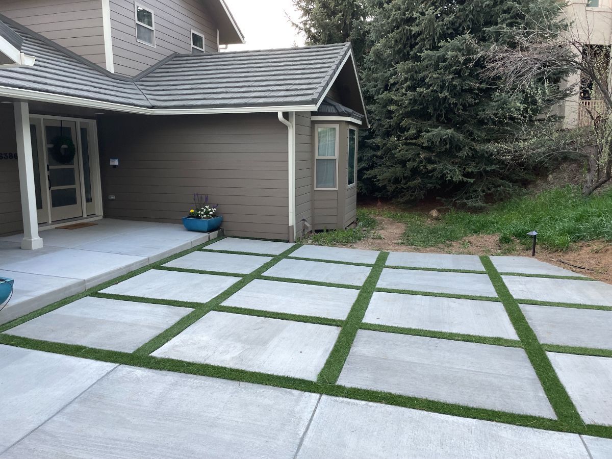 a concrete driveway with grass in the middle of it